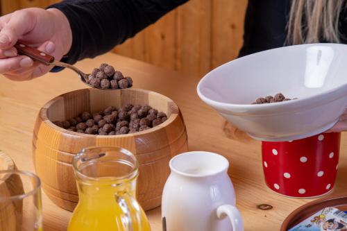 une personne mangeant de la nourriture à partir d'un bol de chips de chocolat dans l'établissement Chalet Košutnik Velika planina, à Kamniška Bistrica