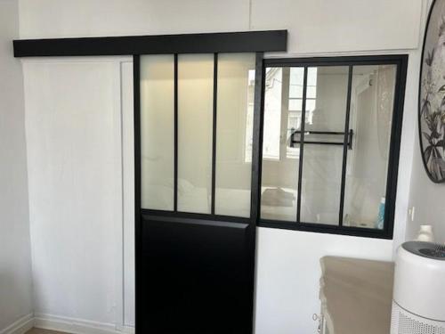 a black door with a window in a room at T2 Ctre ville Fibre Literie Emma in Montrichard