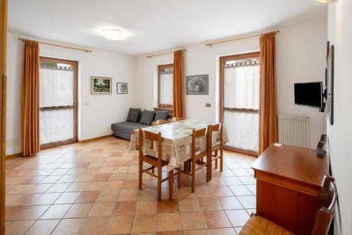 a living room with a table and a couch at Residence Malibu Appartamento 7 in Falcade