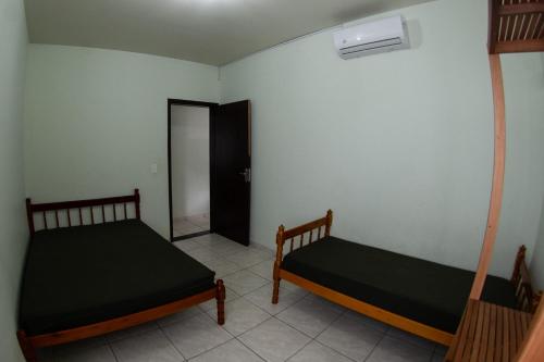 two beds sitting in a room with a door at Residencial Oceano Azul in Itapoa