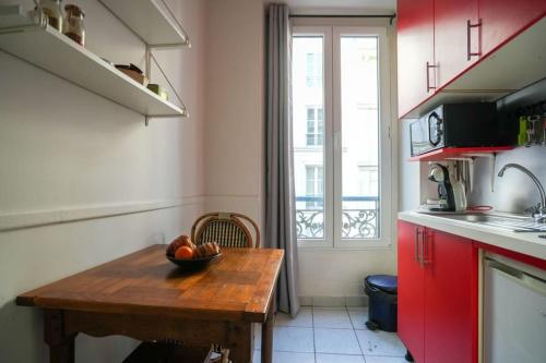 - une cuisine avec une table en bois et un bol de fruits dans l'établissement Lovely studio in Bastille, à Paris