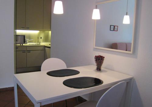 a white table with chairs and a vase of flowers on it at K9 Wohnungen in Münster