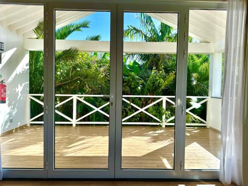an open door to a balcony with palm trees at Azores Casa Hawaii in Nordeste