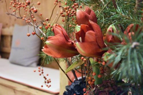 a vase filled with red flowers on a table at Spa & Resort Bachmair Weissach, LUXURY FAMILY RESORT in Rottach-Egern