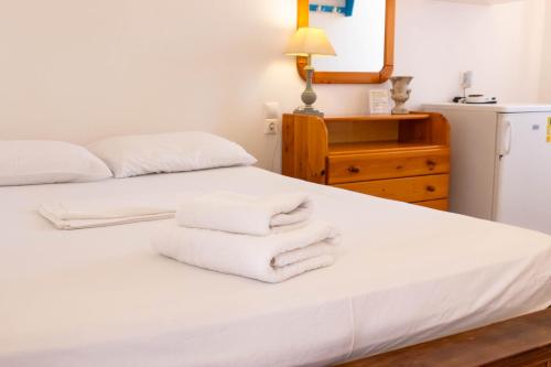 a bedroom with a white bed with towels on it at Sorokos Koufonissia in Koufonisia