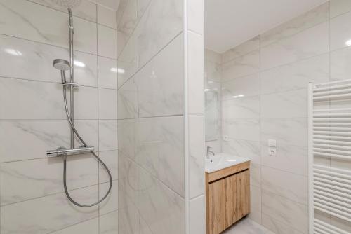 a white bathroom with a shower and a sink at Le Havre du Bois Coquard - Proche Disney in Chessy