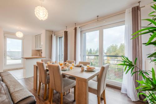 une salle à manger avec une table et des chaises et une grande fenêtre dans l'établissement Le Havre du Bois Coquard - Proche Disney, à Chessy