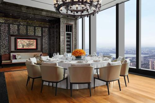 a dining room with a table and chairs and a chandelier at The Ritz-Carlton, Nanjing in Nanjing