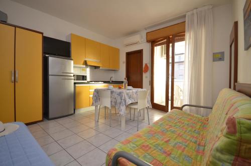 a living room with a table and a kitchen at Appartamenti Foyer in Bibione