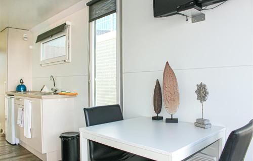 Una cocina y un comedor con una mesa y sillas blancas. en Havenlodge Lelystad, en Lelystad