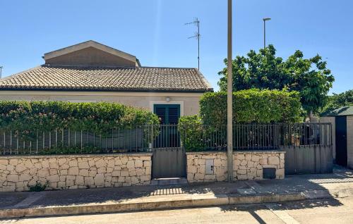 ein Zaun vor einem Haus mit einem Tor in der Unterkunft 3 Bedroom Nice Home In Marina Di Modica in Marina di Modica