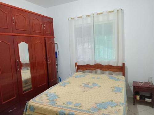 a bedroom with a bed and a large window at Pousada Recanto dos Pássaros in Imaruí