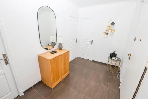 Cette chambre comprend un miroir et une armoire en bois. dans l'établissement Magnifique 3 pièces climatisé proche Monaco, à Roquebrune-Cap-Martin