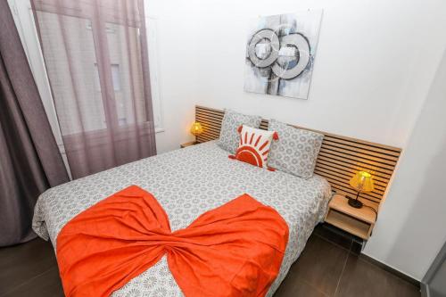 - une chambre avec un lit et une couverture orange dans l'établissement Magnifique 3 pièces climatisé proche Monaco, à Roquebrune-Cap-Martin