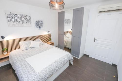 - une chambre blanche avec un lit blanc et une porte dans l'établissement Magnifique 3 pièces climatisé proche Monaco, à Roquebrune-Cap-Martin