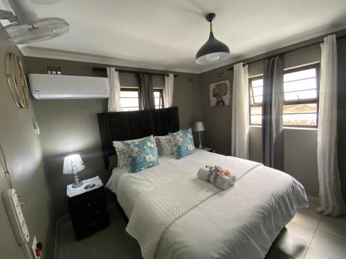 a bedroom with a bed with two stuffed animals on it at Fish Eagle Place in Durban