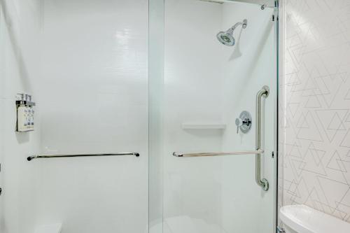 a shower with a glass door next to a toilet at Holiday Inn Express Hotel & Suites Columbus Airport by IHG in Gahanna