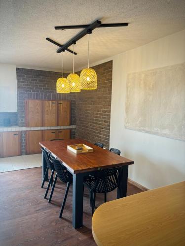 a dining room with a table with chairs and lights at 3 bedroom house with magnificent ocean views in Hentiesbaai