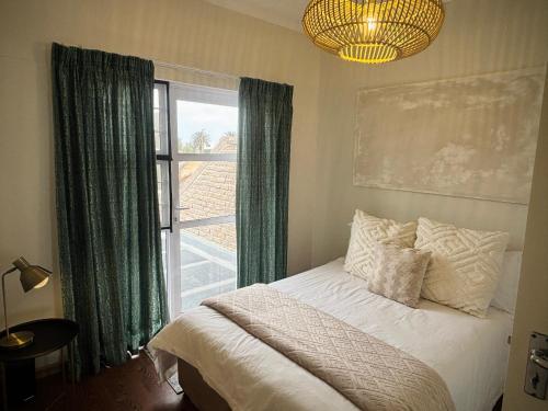 a bedroom with a bed and a large window at 3 bedroom house with magnificent ocean views in Hentiesbaai