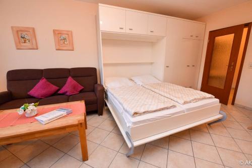 a bedroom with a bed and a couch and a table at Haus "Luv und Lee" Appartement LEE01 in Döse