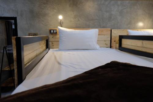 a bed with white sheets and pillows in a room at Yaowarate Sport Club and Resort ไร่เยาวเรศ in Ban Mae Ho Phra