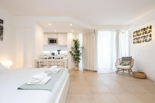 a white living room with a couch and a kitchen at Apartamento Golden Naimara in Cabanas de Tavira