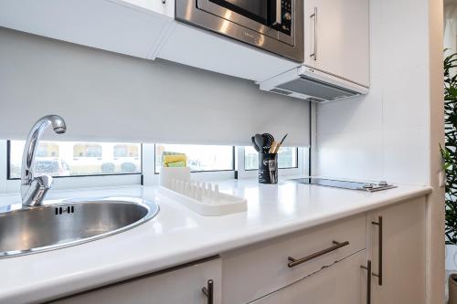 a kitchen with a sink and a microwave at Apartamento Golden Naimara in Cabanas de Tavira
