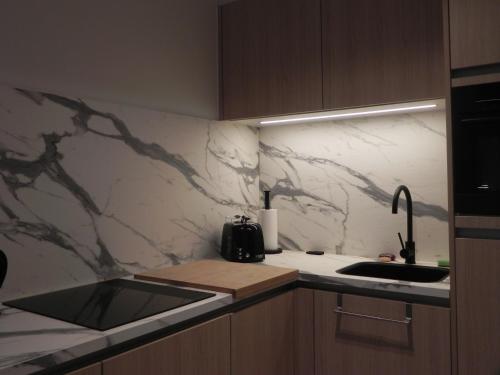 a kitchen with a sink and a marble counter top at Silver Sunrise Studio in De Haan