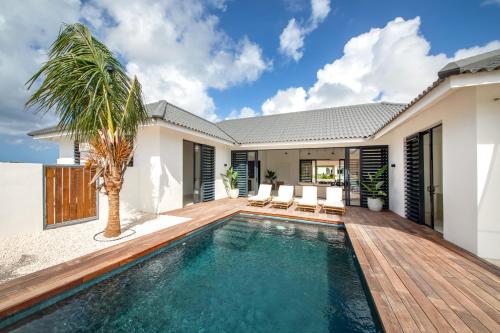 a swimming pool in the backyard of a house at Villa Encanto del Agua in Jan Thiel
