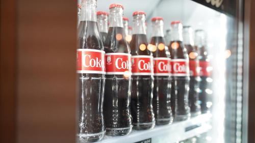 a row of coke bottles in a refrigerator at Amical Hotel Hagen - Am Hauptbahnhof in Hagen