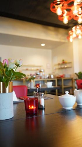 a table with a candle and a vase of flowers at Amical Hotel Hagen - Am Hauptbahnhof in Hagen
