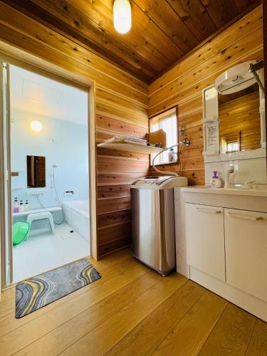 a kitchen with wooden walls and a sliding glass door at Stella Rental Villa Engawa House in Fujikawaguchiko