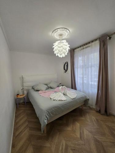 a bedroom with a bed and a chandelier at The Smile House // Bussy-Saint-Georges in Bussy-Saint-Georges