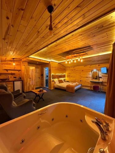 una bañera en una habitación con dormitorio en Özden Bungalow, en Çamlıhemşin
