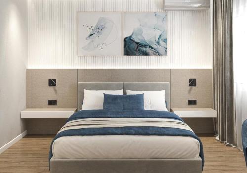 a bedroom with a large bed with two pictures on the wall at Sliv in Vinica