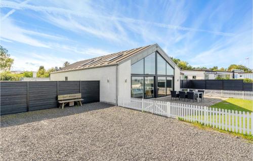 a white house with a fence and a bench at 4 Bedroom Amazing Home In Strøby in Strøby
