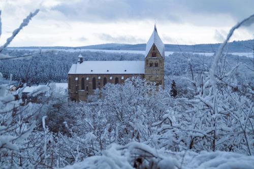 a large brick building with a steeple in the snow at Ferienwohnung Domblick in Ravengiersburg