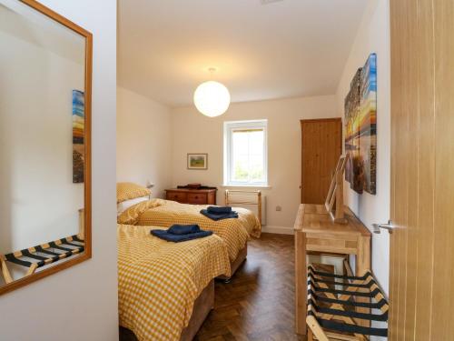 a bedroom with two beds and a mirror at Tirlaggan Úr in Oban