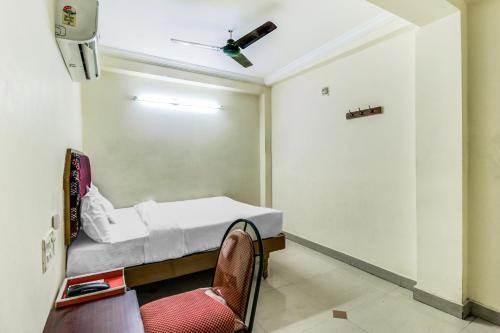 a small room with a bed and a chair at SPOT ON Swarna Mayuri in Guntūr