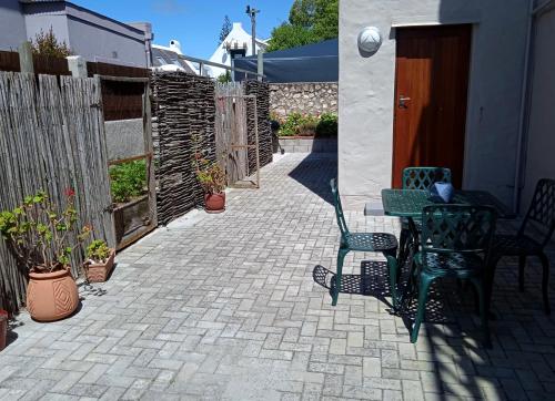 a patio with a table and chairs and a fence at 8 On Main in Witsand