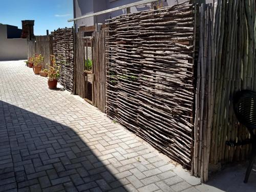 a wooden fence with plants on it next to a sidewalk at 8 On Main in Witsand