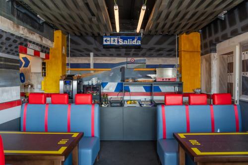 a restaurant with red and blue chairs and a kitchen at Hotel Monasterio Granada - Adults Only in Granada