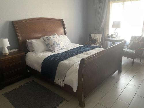 a bedroom with a bed with a wooden headboard and pillows at Krantz-Aloe guesthouse in Winterkamp