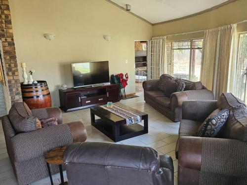 a living room with couches and a flat screen tv at Krantz-Aloe guesthouse in Winterkamp