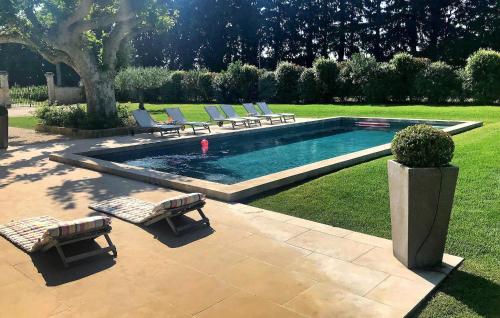 Una piscina con tumbonas en un patio. en Lovely Home In Le Thor With Wifi, en Le Thor