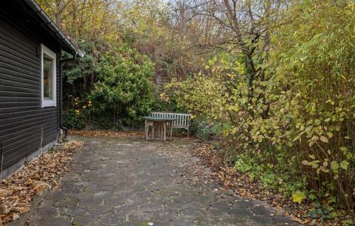 a bench sitting on a path next to a house at Cozy Home In Frederiksværk With Wifi in Frederiksværk