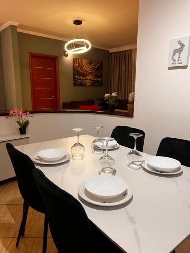 a white table with chairs and plates and wine glasses at Legacy Loft 1 in Durrës
