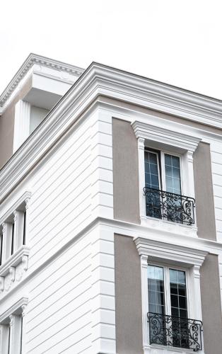 a white building with windows and a balcony at Oxygen Boutique Hotel in Tirana