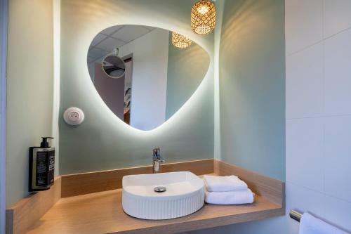 a bathroom with a sink and a mirror at ibis Styles Pontivy centre Bretagne in Pontivy