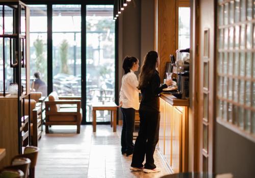 two women standing at a counter in a restaurant at Oxygen Boutique Hotel in Tirana
